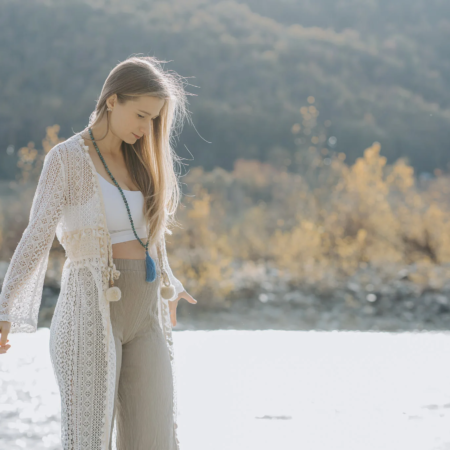 Betatrice mazza incinta sulle rive di un fiume pratica yoga